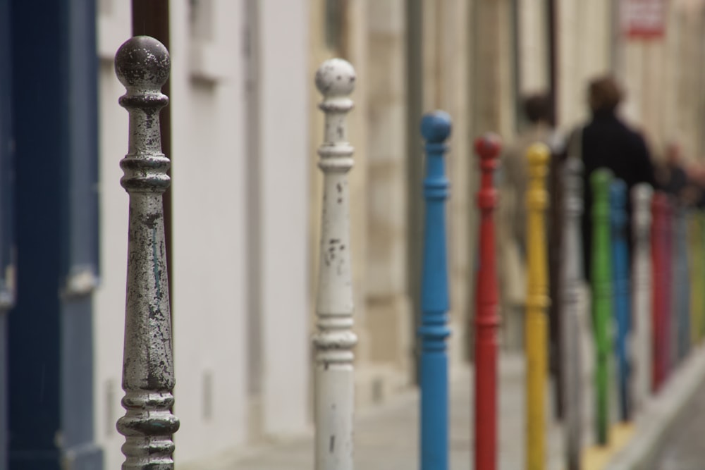 a row of colorful poles next to a building
