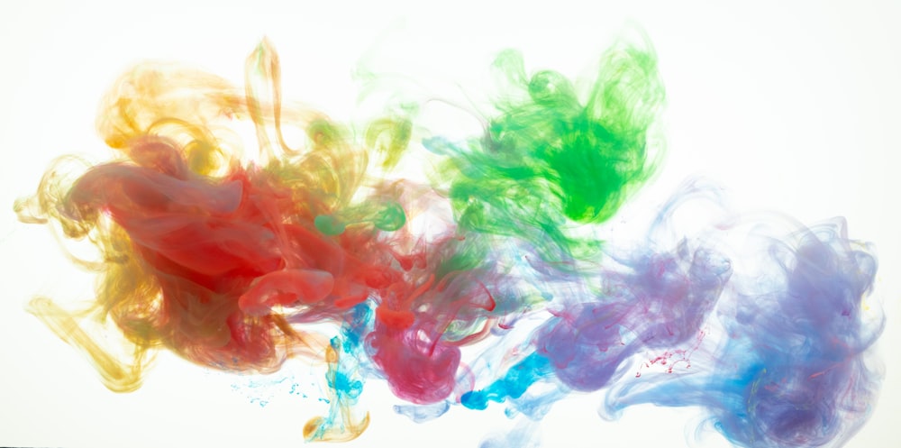 a group of multicolored inks floating in the air