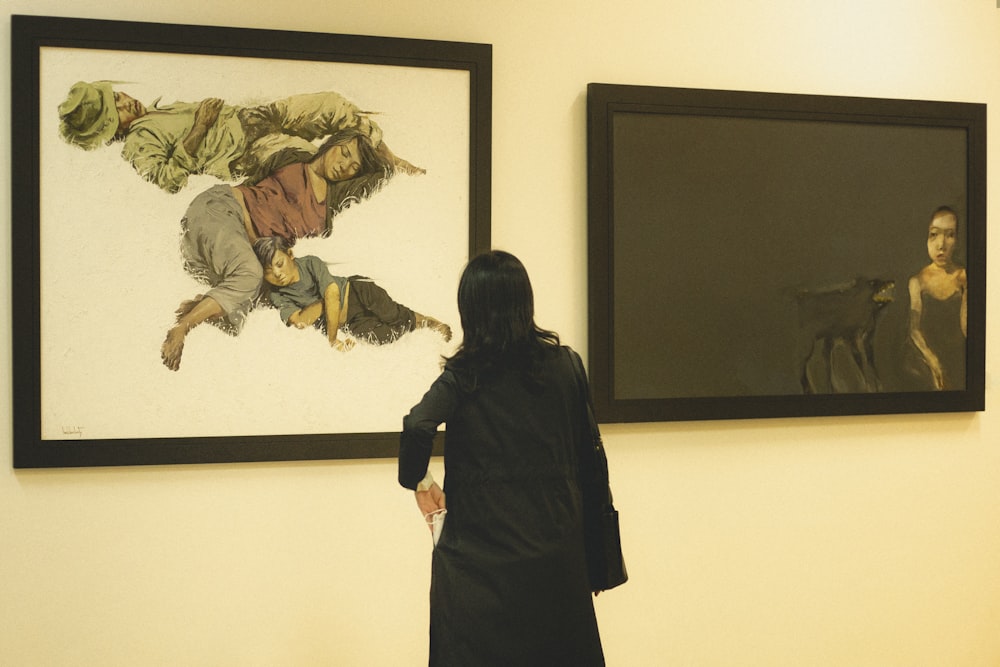 a woman standing in front of two paintings