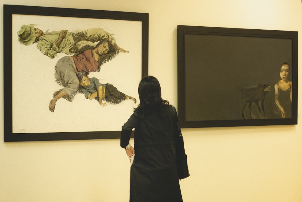 Eine Frau steht vor zwei Gemälden