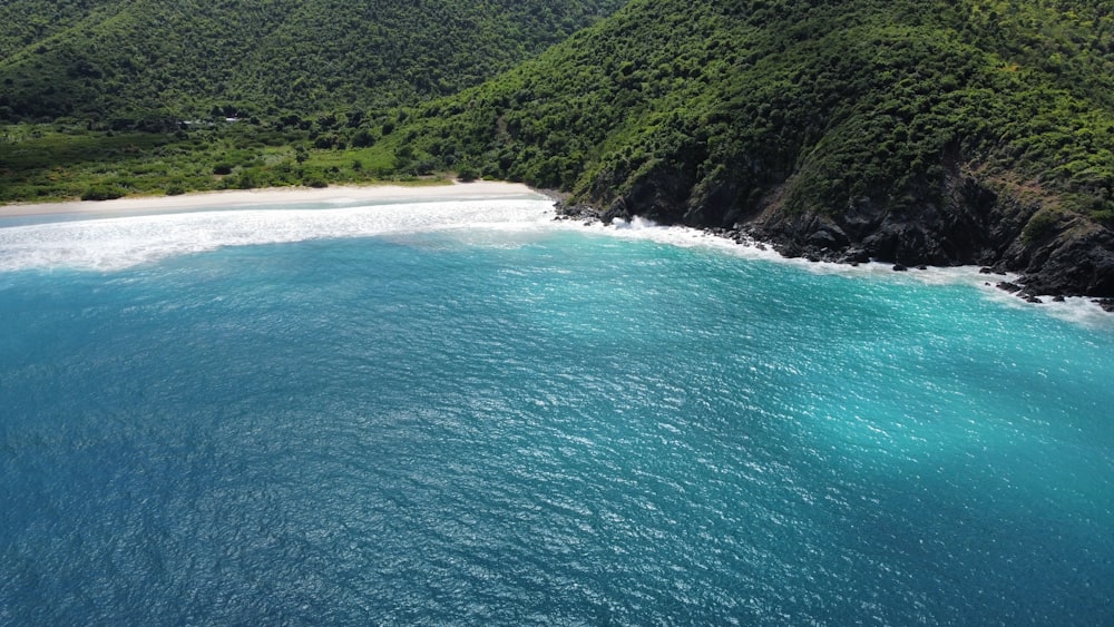 an aerial view of a beach with a mountain in the background