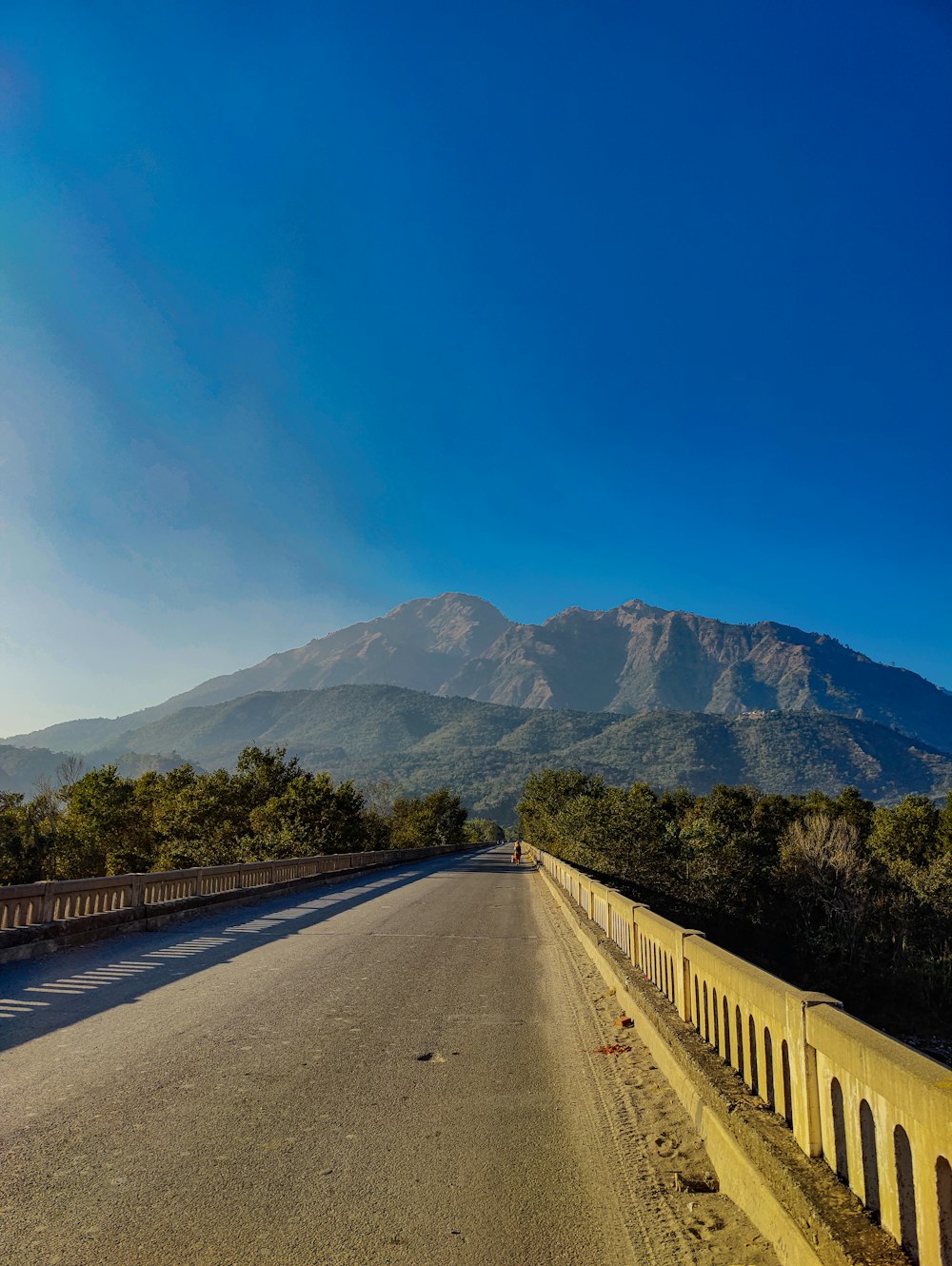 an empty road with a mountain in the background