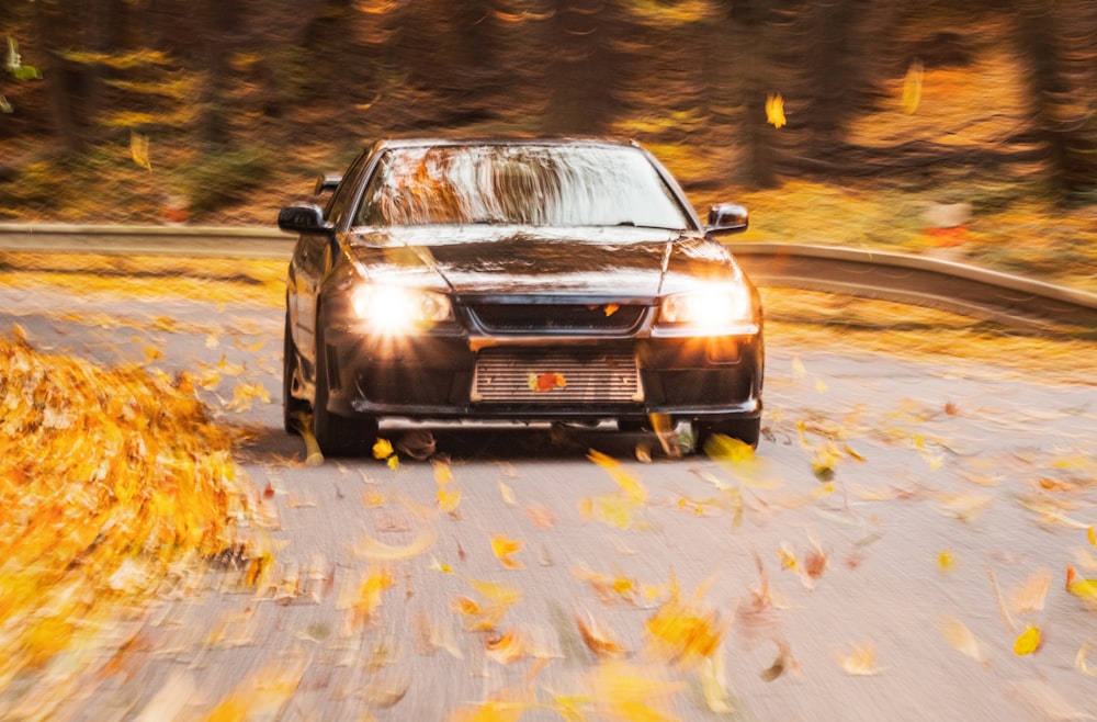 a car driving down a road in the fall