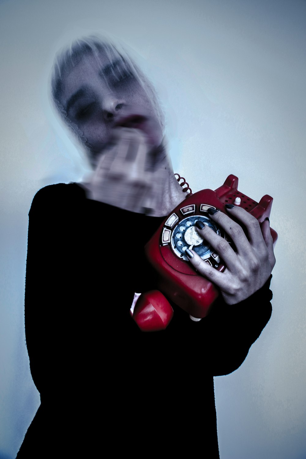 a woman in a black shirt holding a red phone