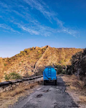 A water truck navigating rugged terrain to deliver water during wildfire disaster relief efforts.