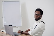 a man sitting at a table with a laptop in front of him
