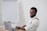 a man sitting at a table with a laptop in front of him