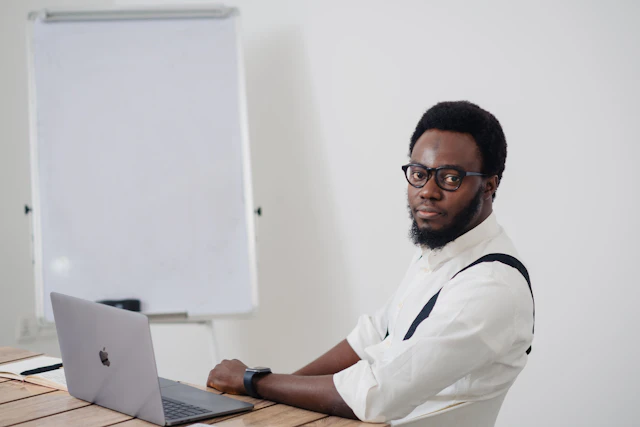 Nigerian professional studying at a table with a laptop