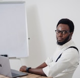 a man sitting at a table with a laptop in front of him