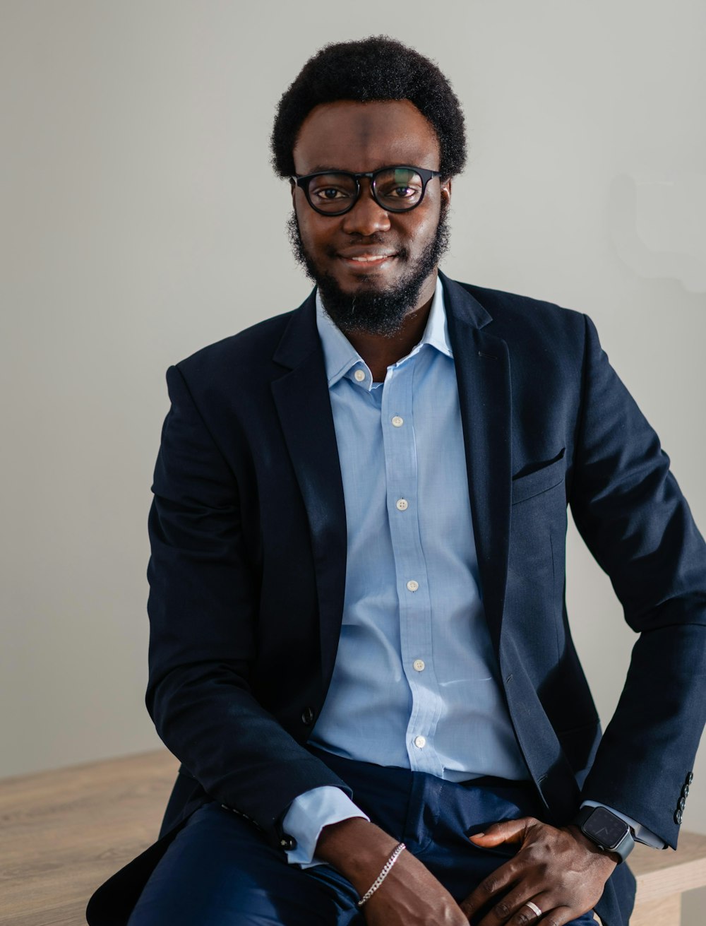 a man in a suit and glasses sitting on a bench