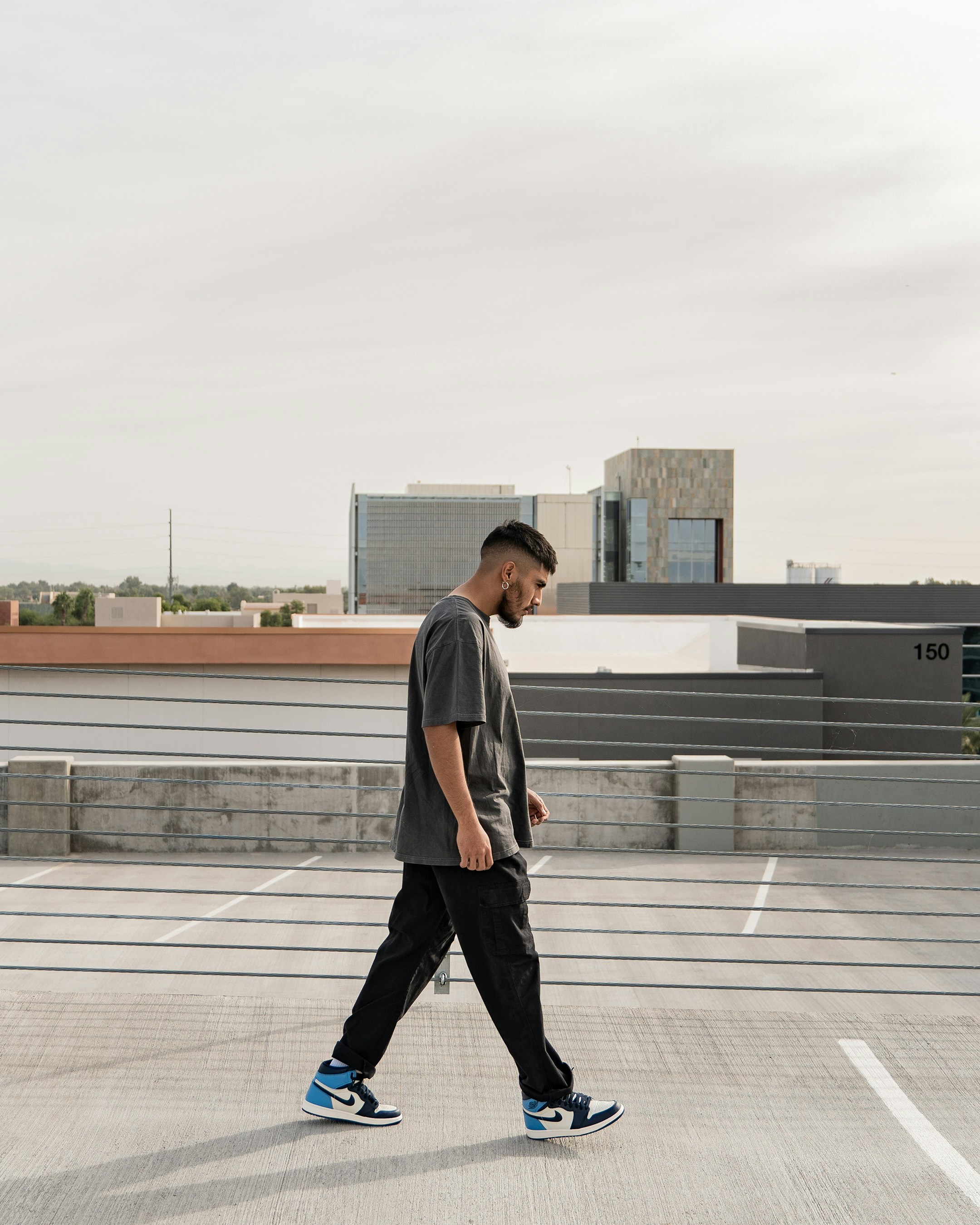a man walking across an empty parking lot