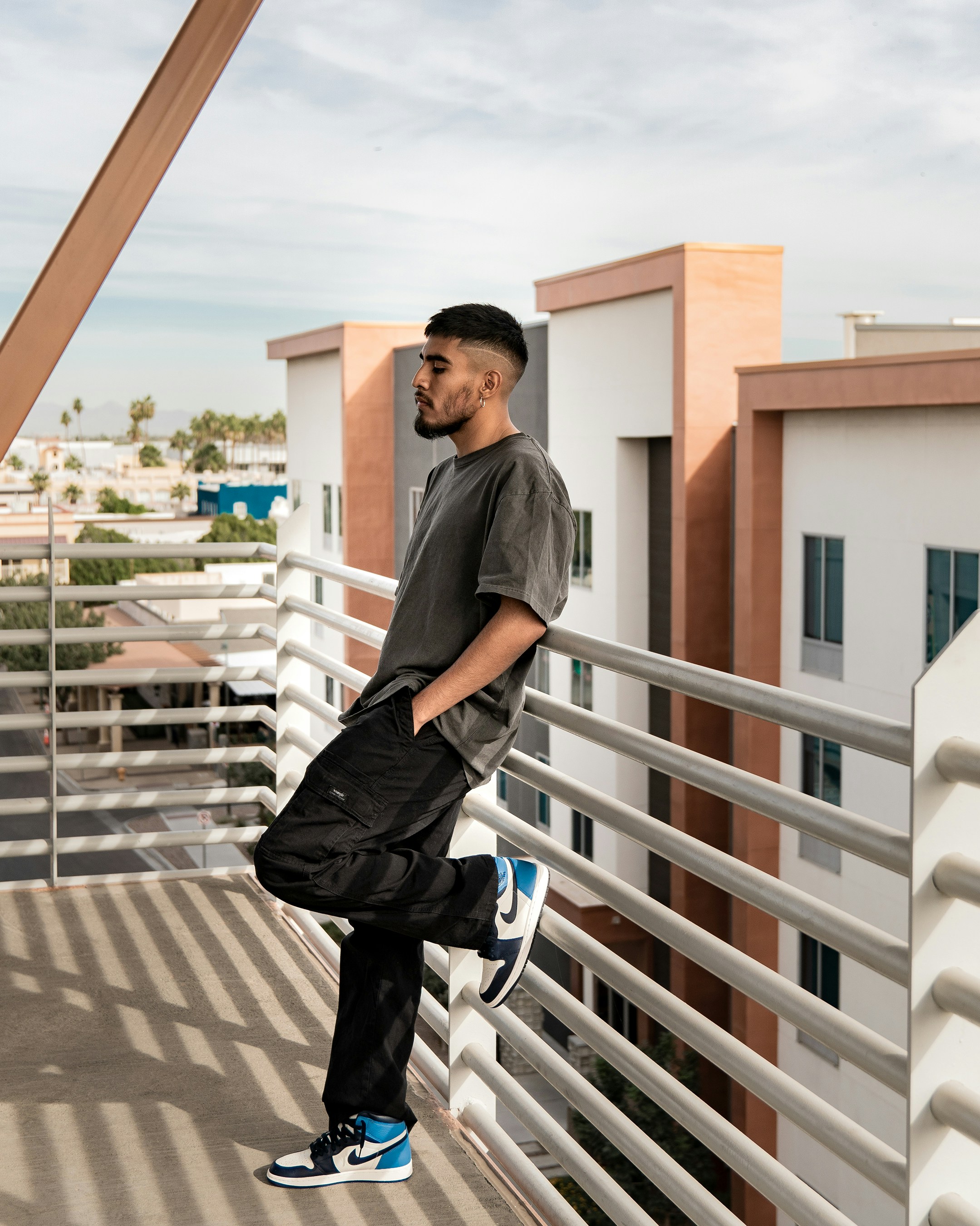 a man standing on a balcony next to a building