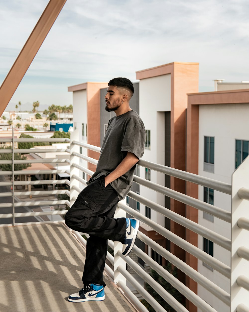 a man standing on a balcony next to a building