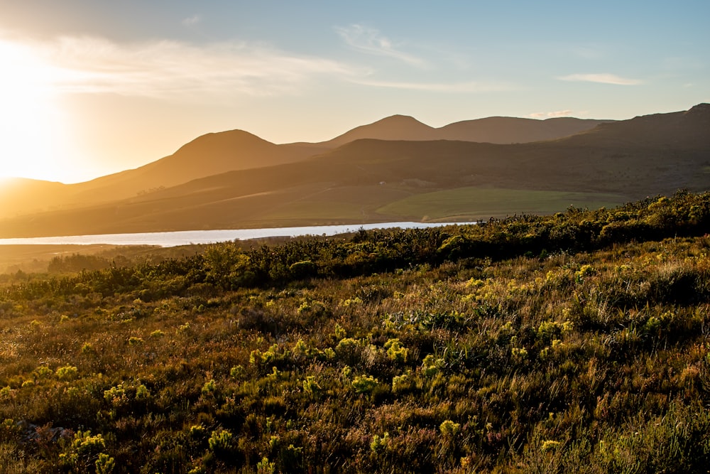 the sun is setting over a mountain range