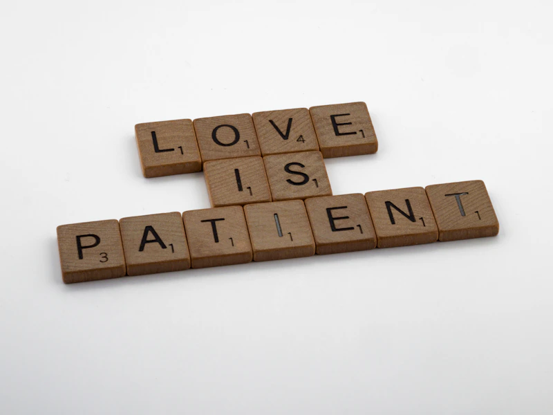 a scrabble of scrabble tiles spelling love is patient