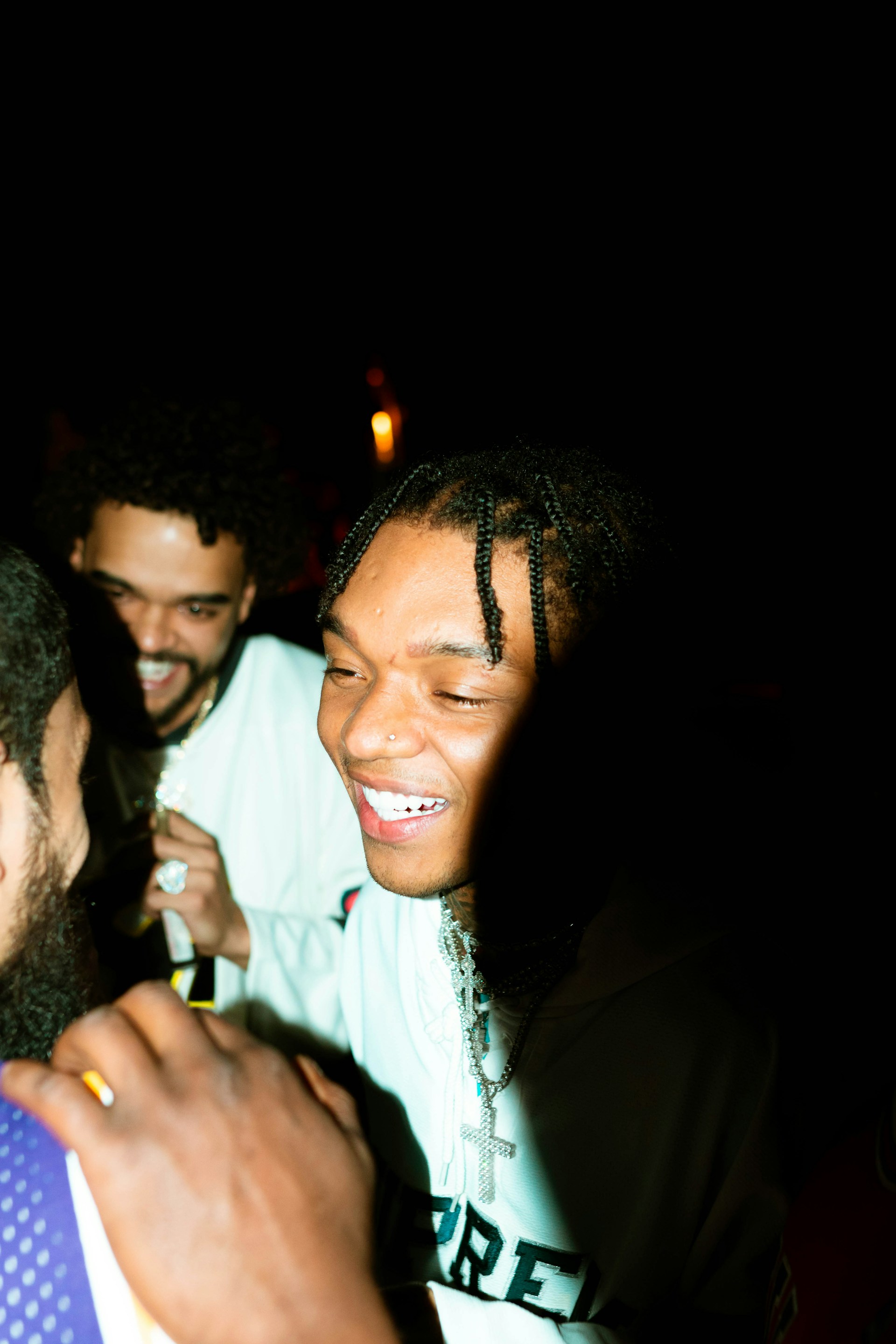 An intimate moment of friends sharing a laugh near a graffiti-covered wall, bathed in the warm glow of after-hours city lights.