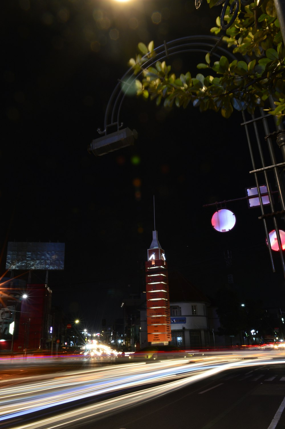 a city street at night with a clock tower in the background