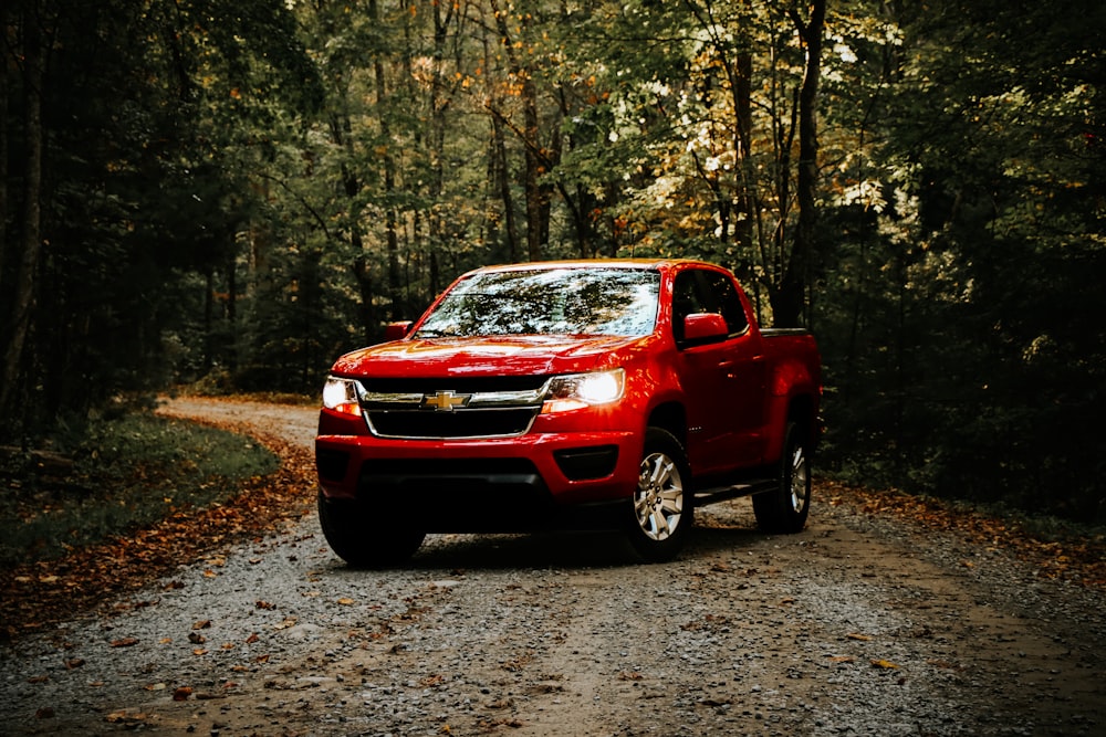 a red truck is driving down a dirt road