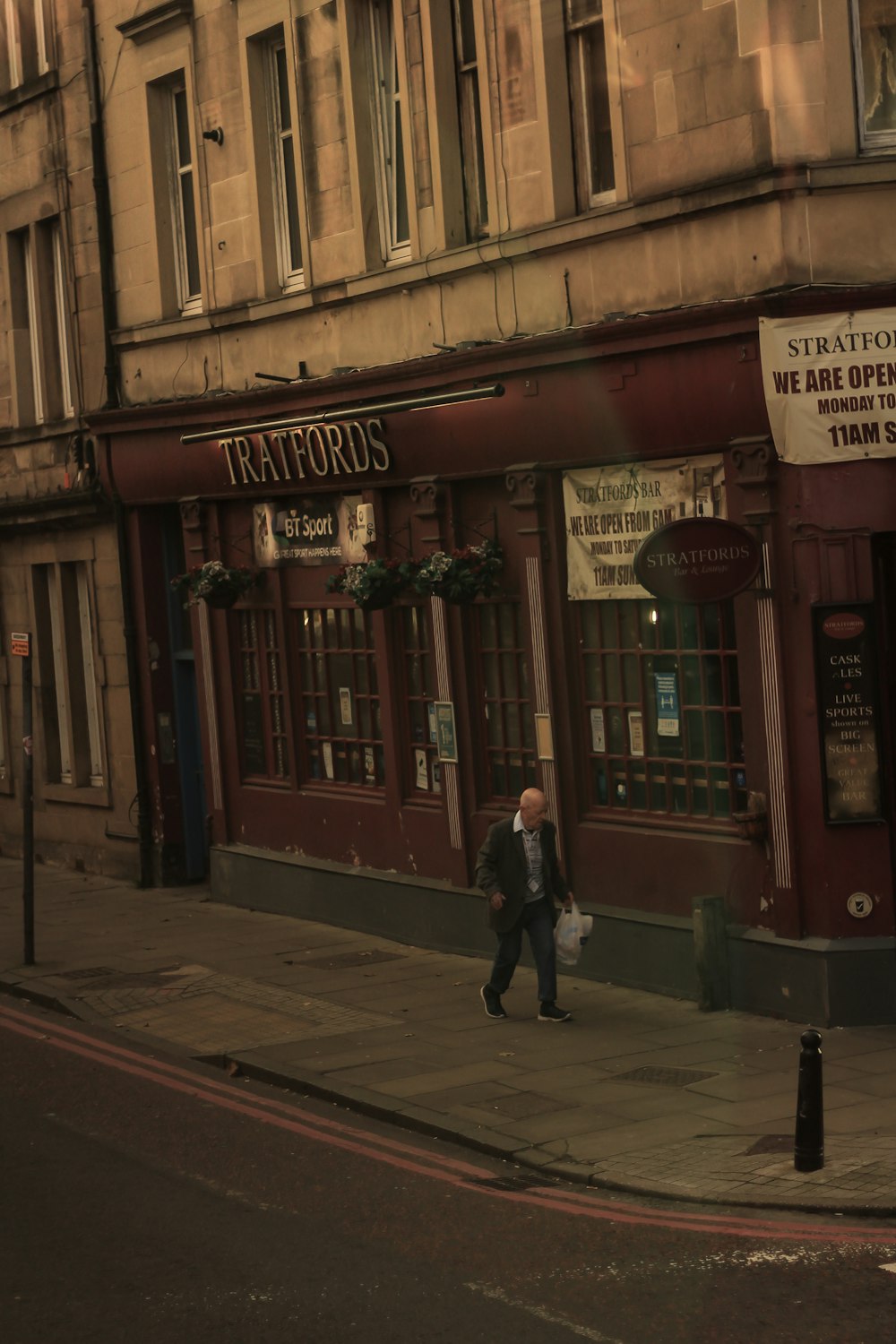 a man walking down the street in front of a store