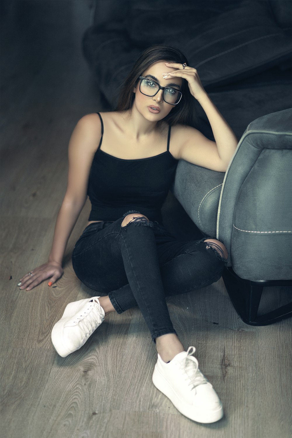 a woman sitting on the floor wearing glasses