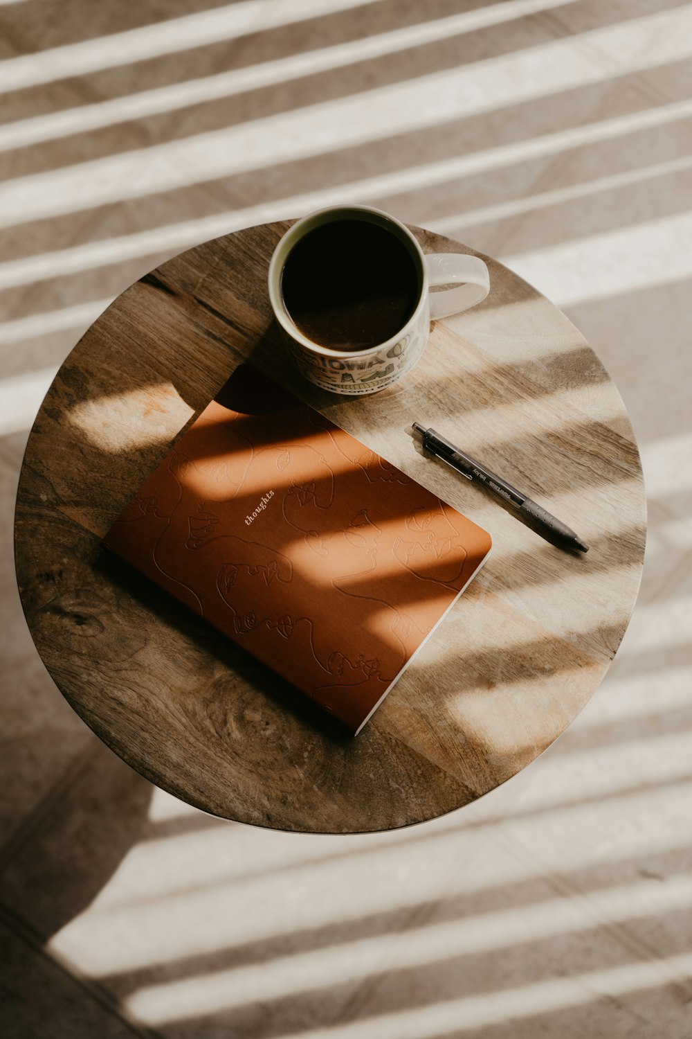 uma xícara de café e um caderno em uma mesa