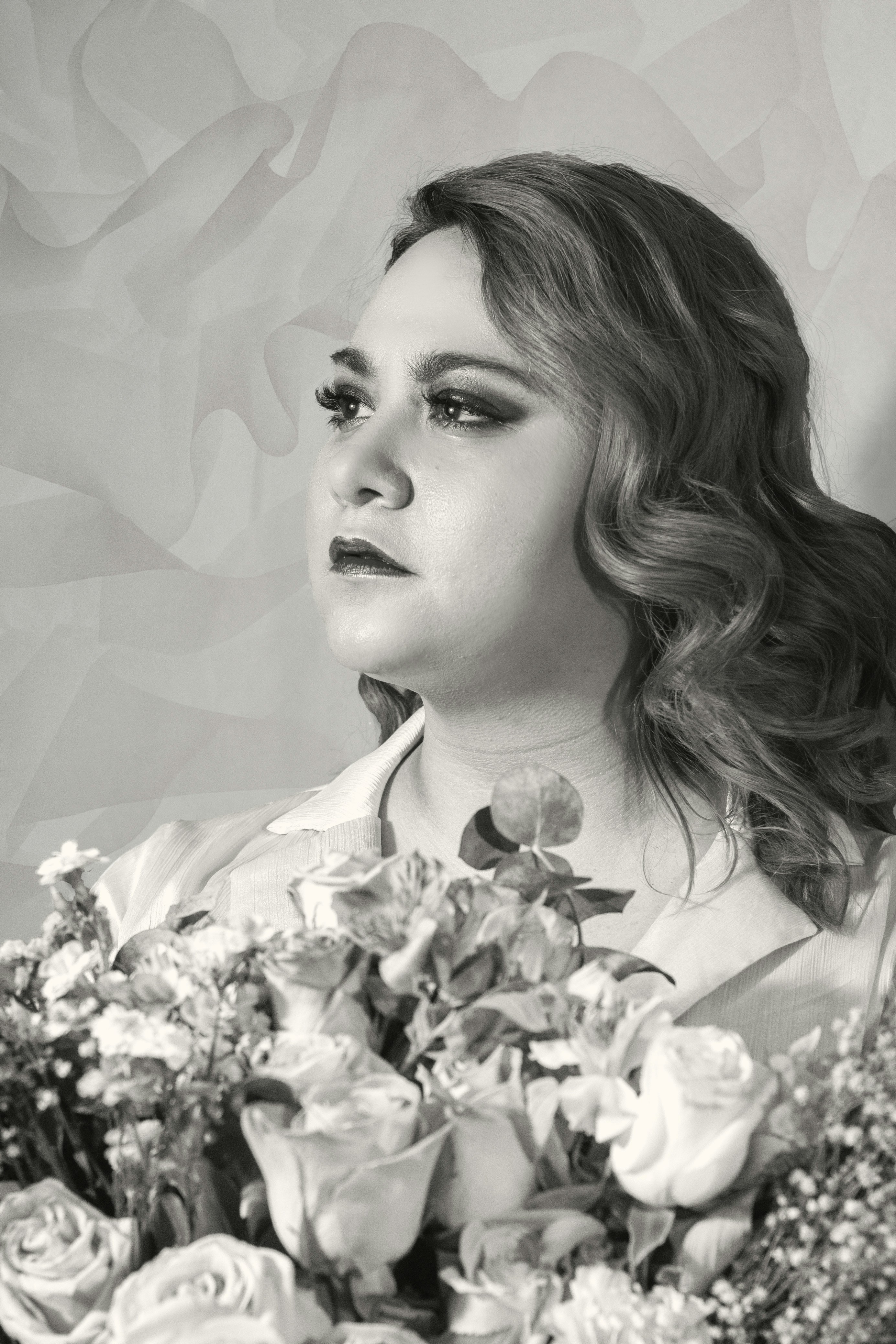 a black and white photo of a woman holding a bouquet of flowers