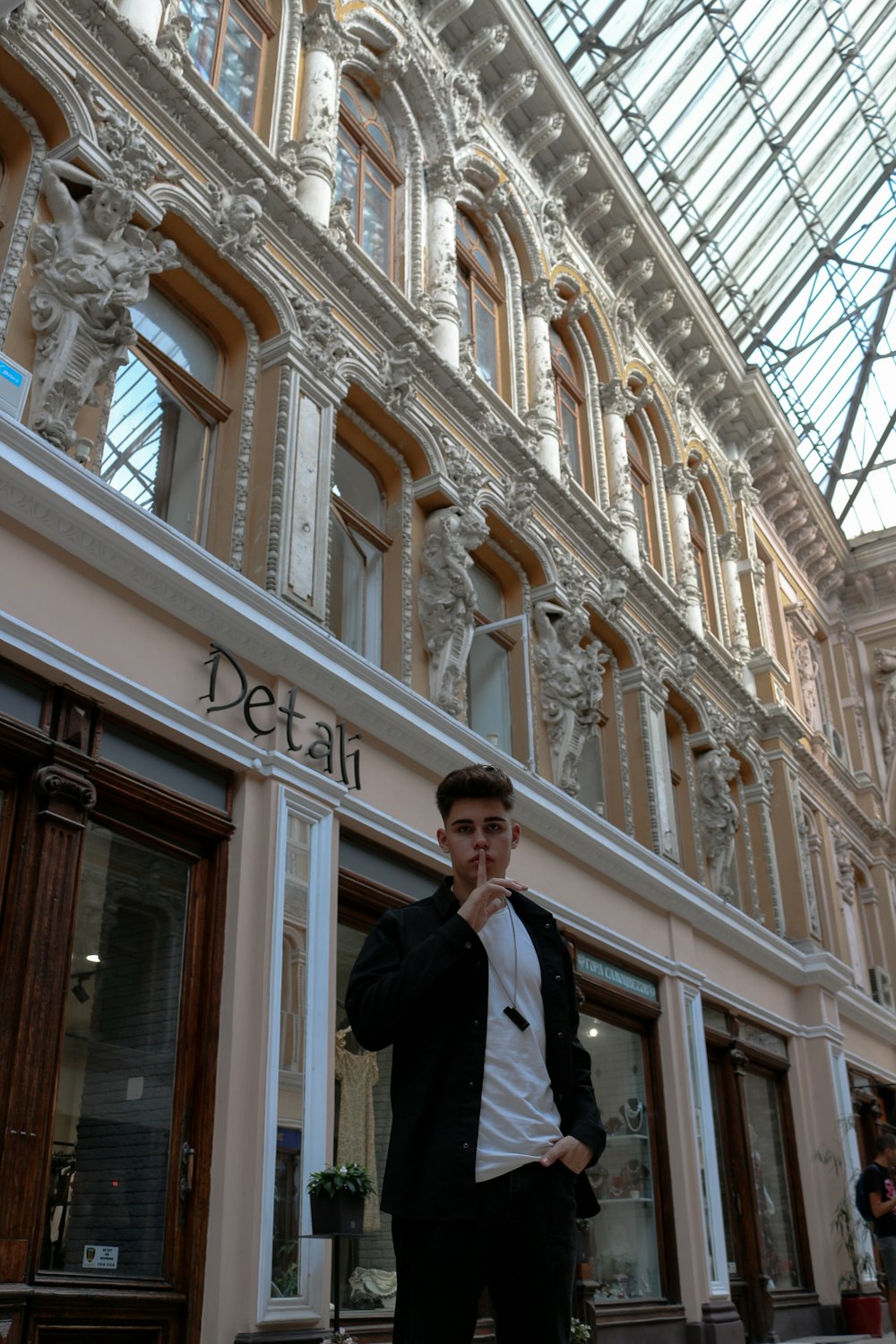 a man standing in front of a building talking on a cell phone