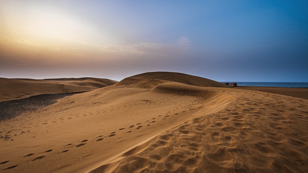 Die Sonne geht über den Sanddünen unter