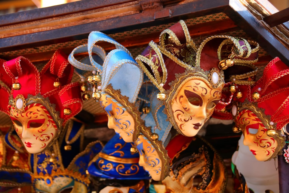 a group of colorful masks hanging from a ceiling