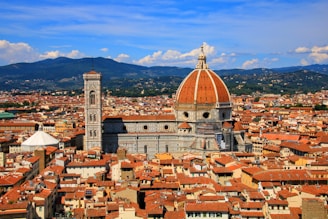 a view of a city with a dome and mountains in the background