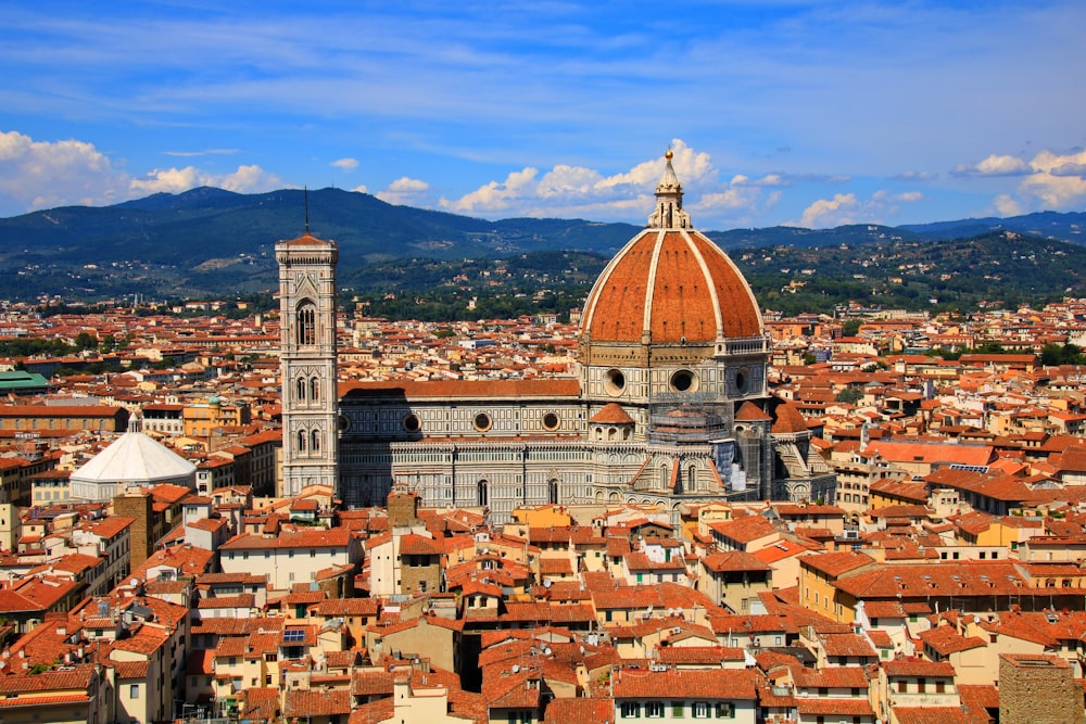 a view of a city with a dome and mountains in the background