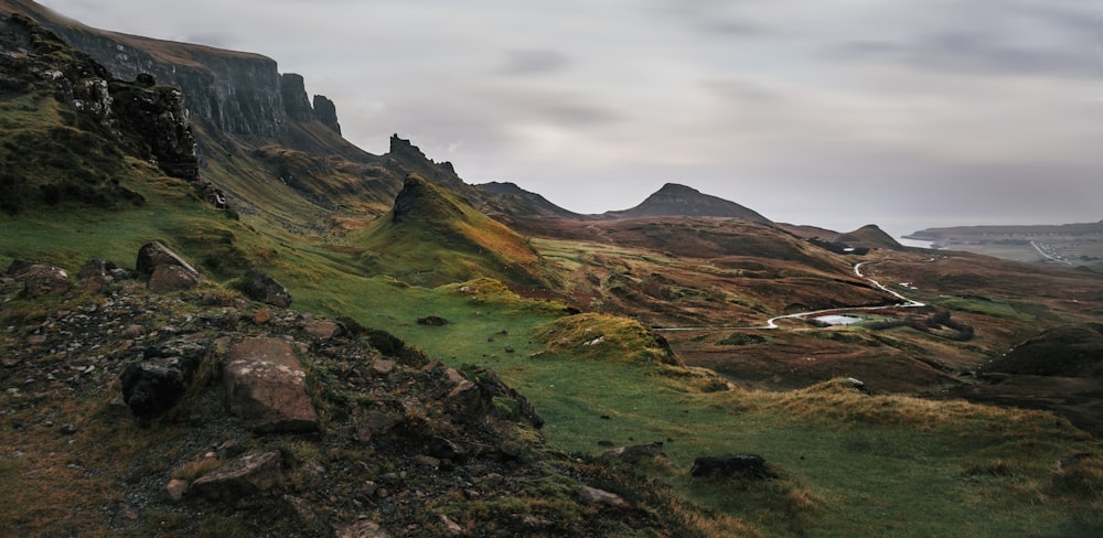 a grassy hill with a road going through it