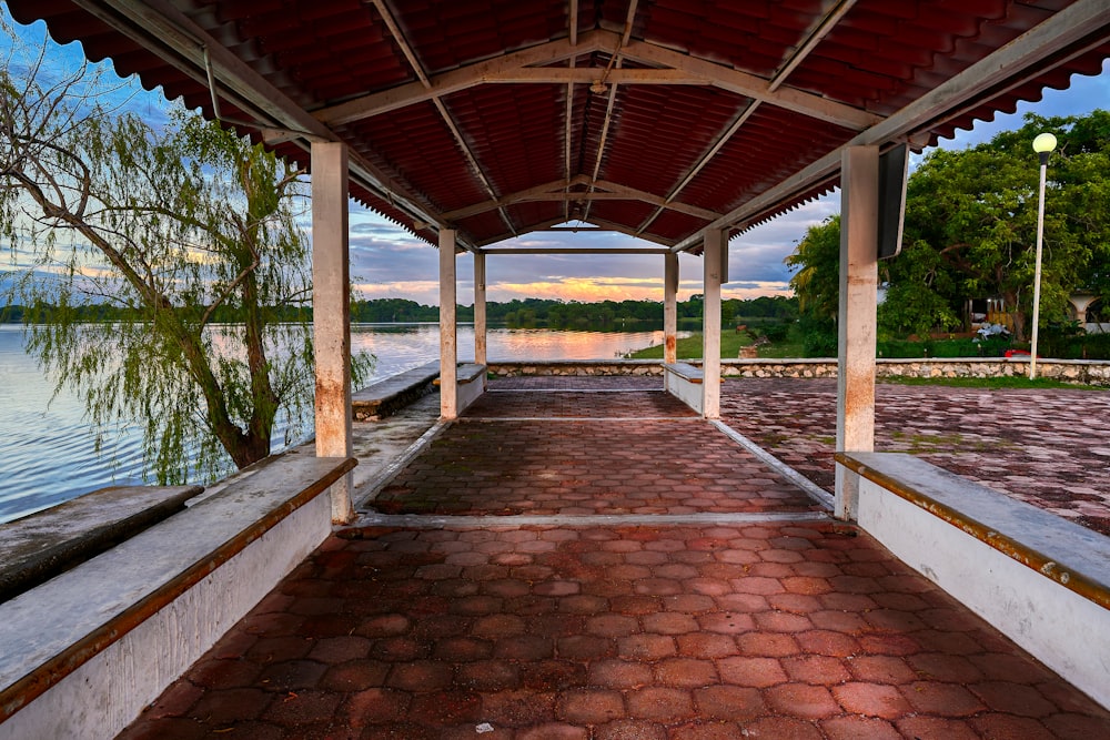 a covered walkway next to a body of water