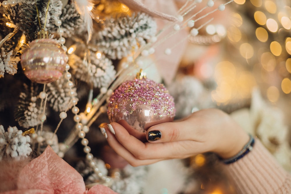 a close up of a person holding a christmas ornament