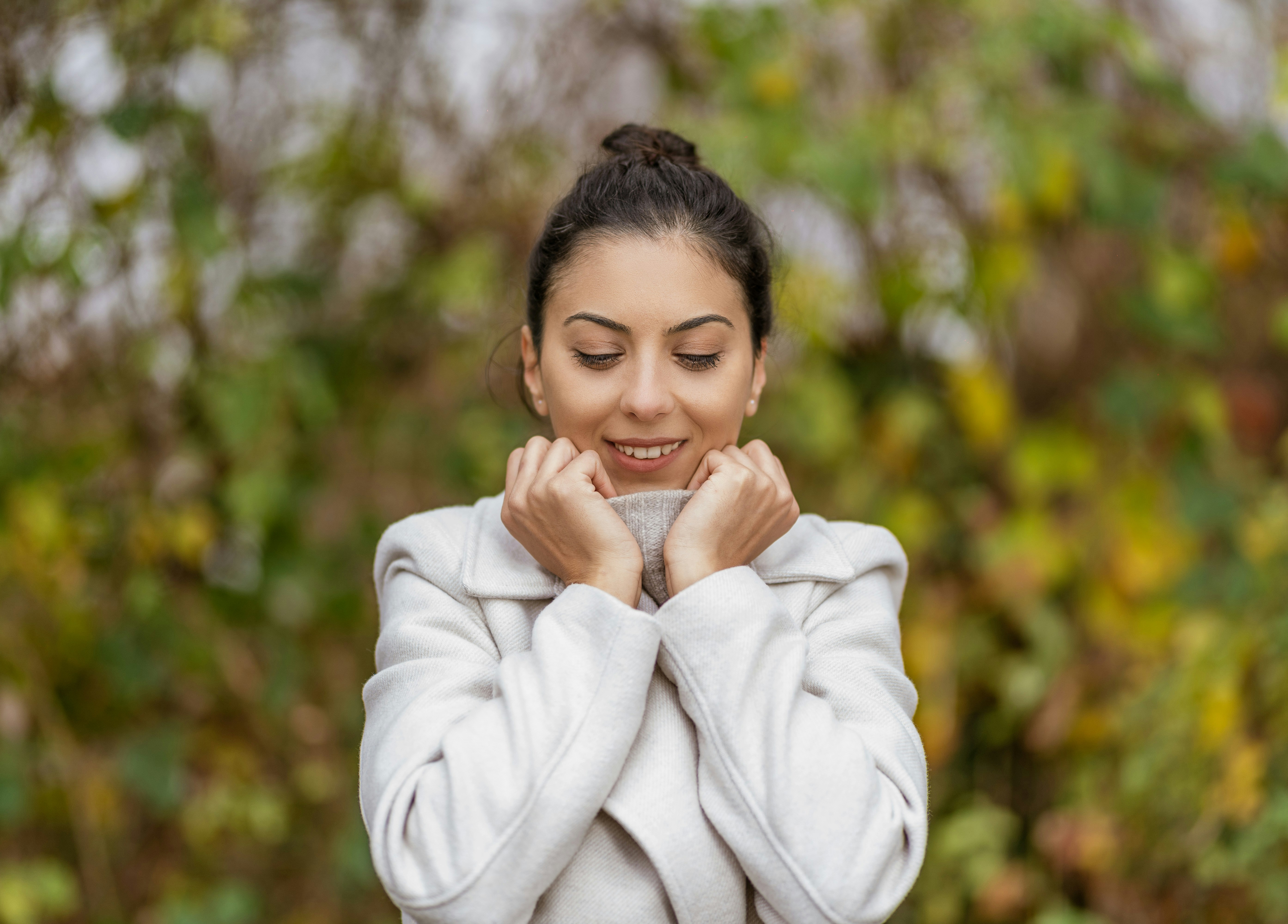 a woman in a white coat holding a cup of coffee
