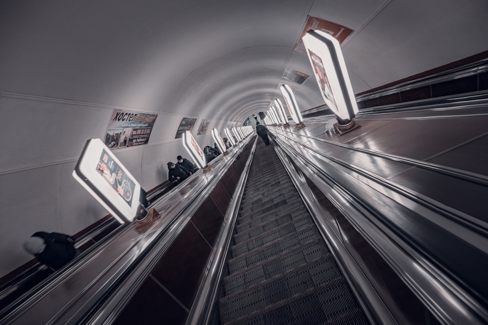 an escalator in a subway station with people on the escalator