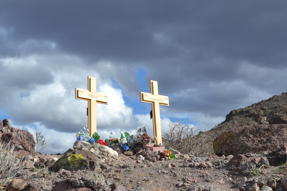 a couple of crosses sitting on top of a rocky hill
