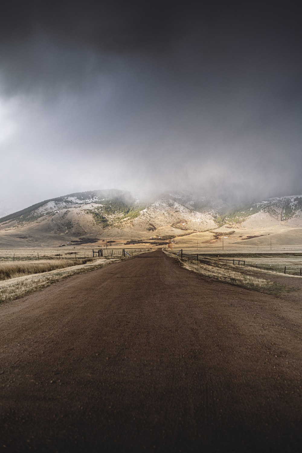 a dirt road with a mountain in the background