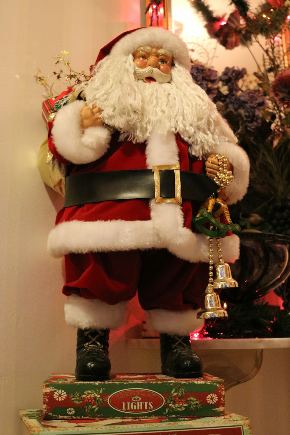 a statue of a santa clause holding a bell