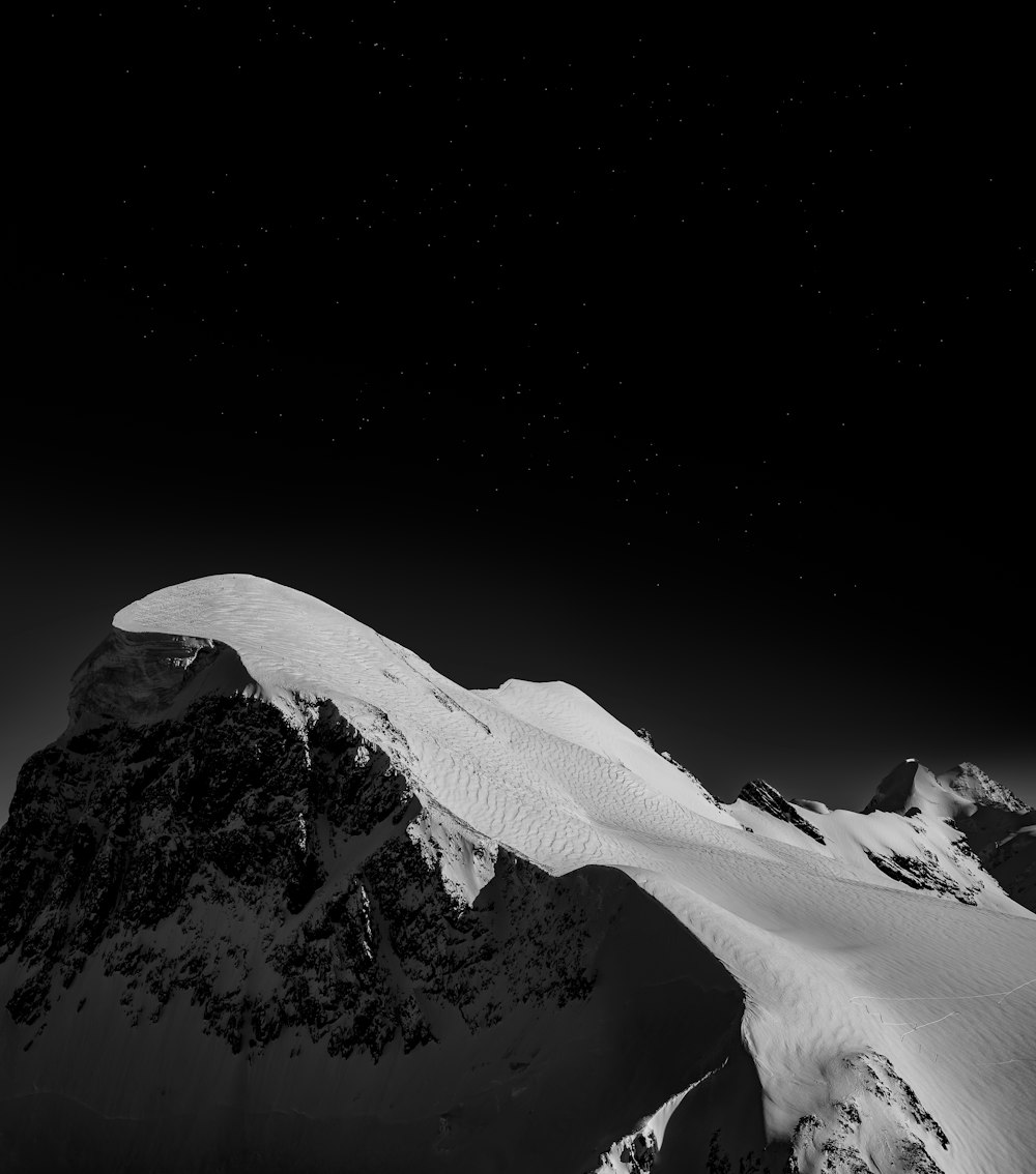 a black and white photo of a snow covered mountain