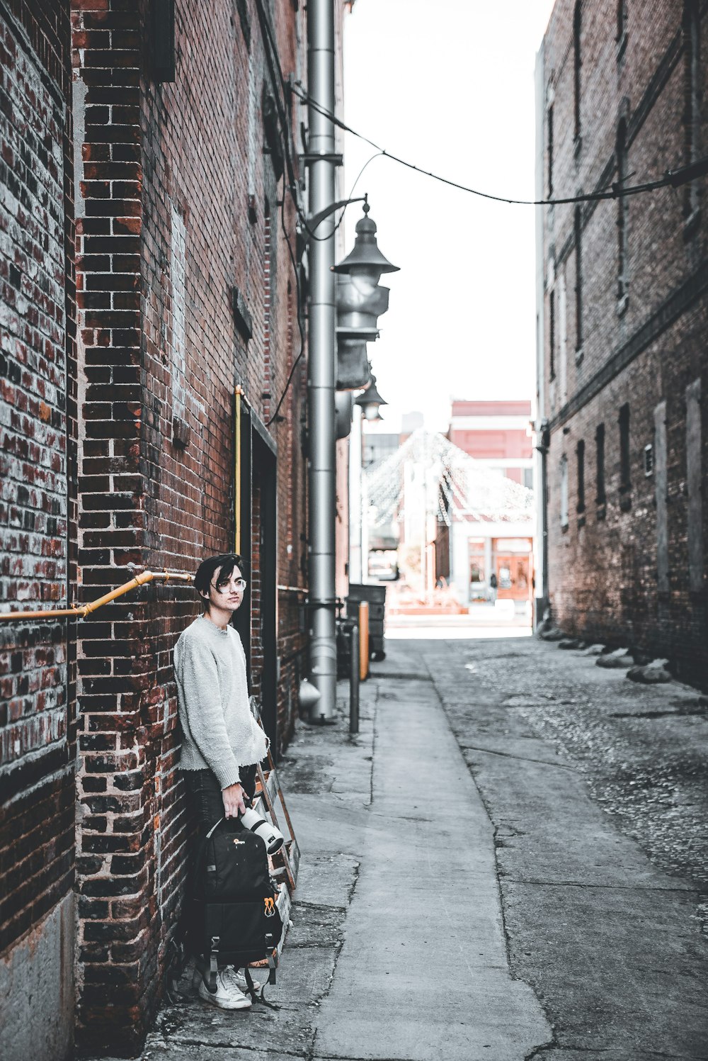 a man standing next to a brick building