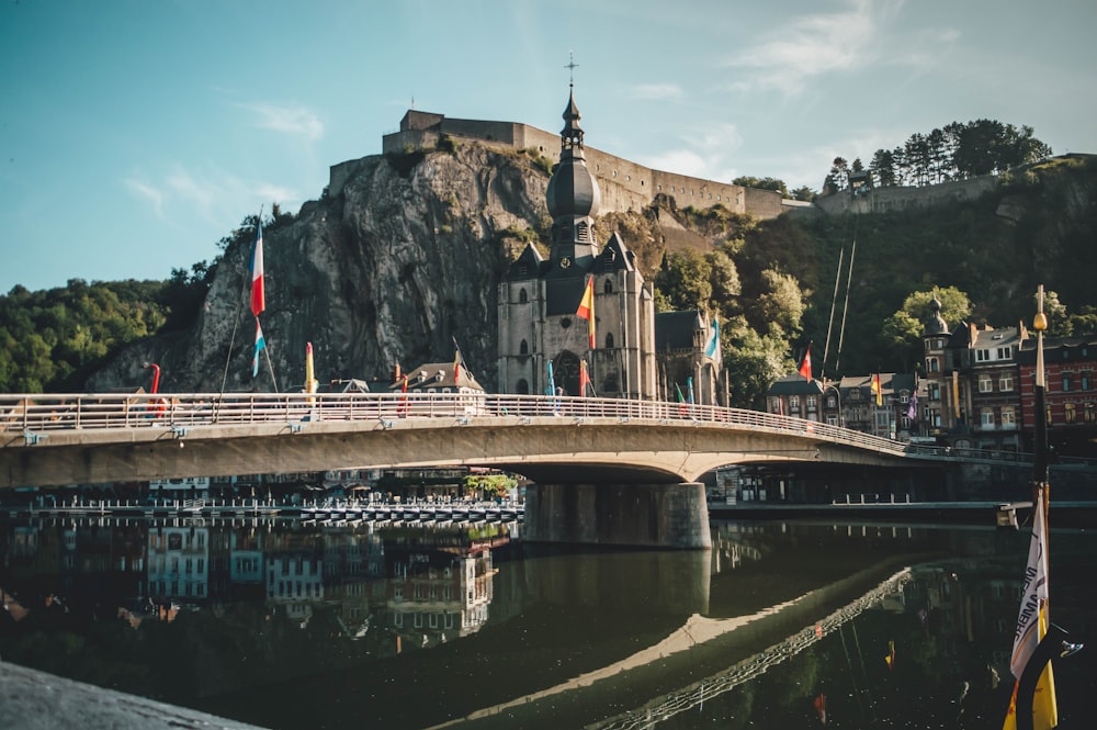 a bridge over a body of water with a castle in the background