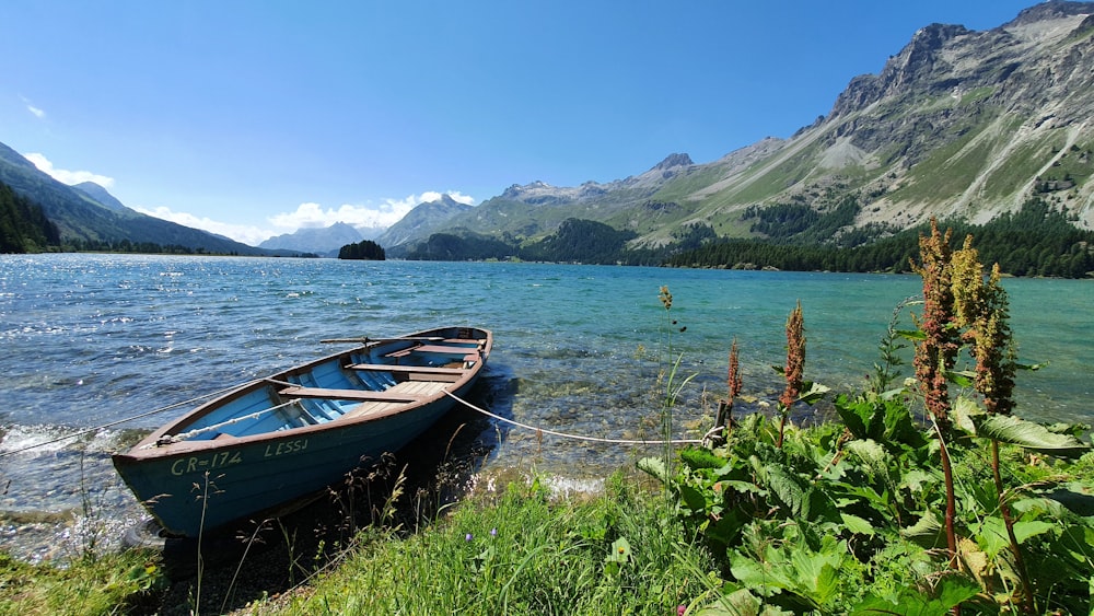 a small boat tied to the shore of a lake