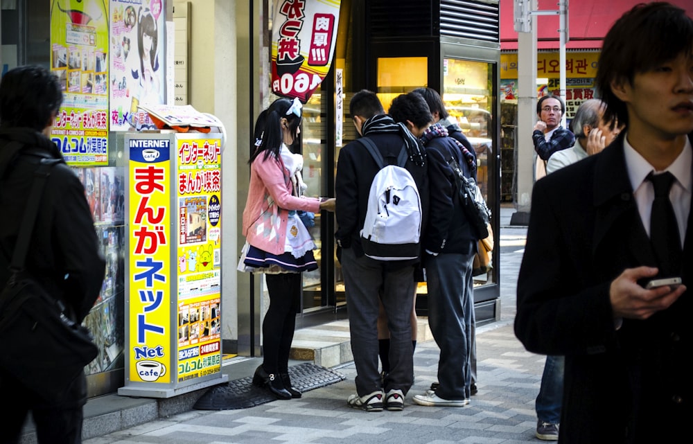 a group of people standing in front of a store