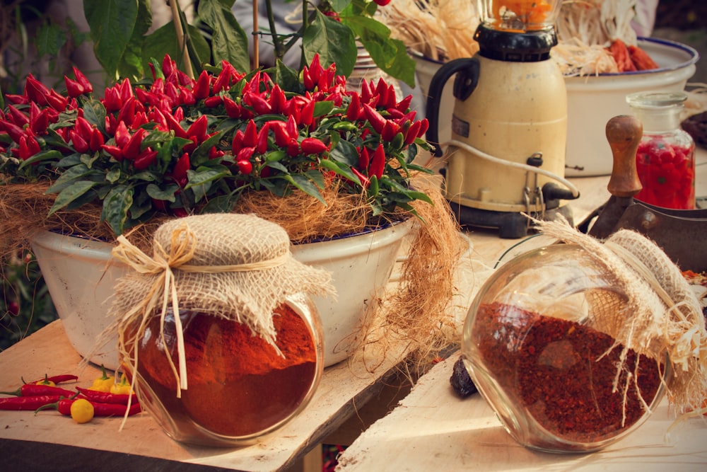 a table topped with pots filled with red flowers