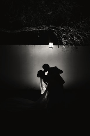 Elegant couple sharing a quiet moment in a softly lit, modern romantic setting.