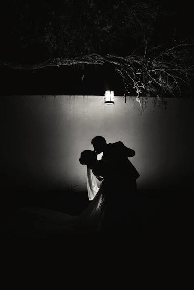 Elegant couple sharing a quiet, intimate moment in soft violet lighting.