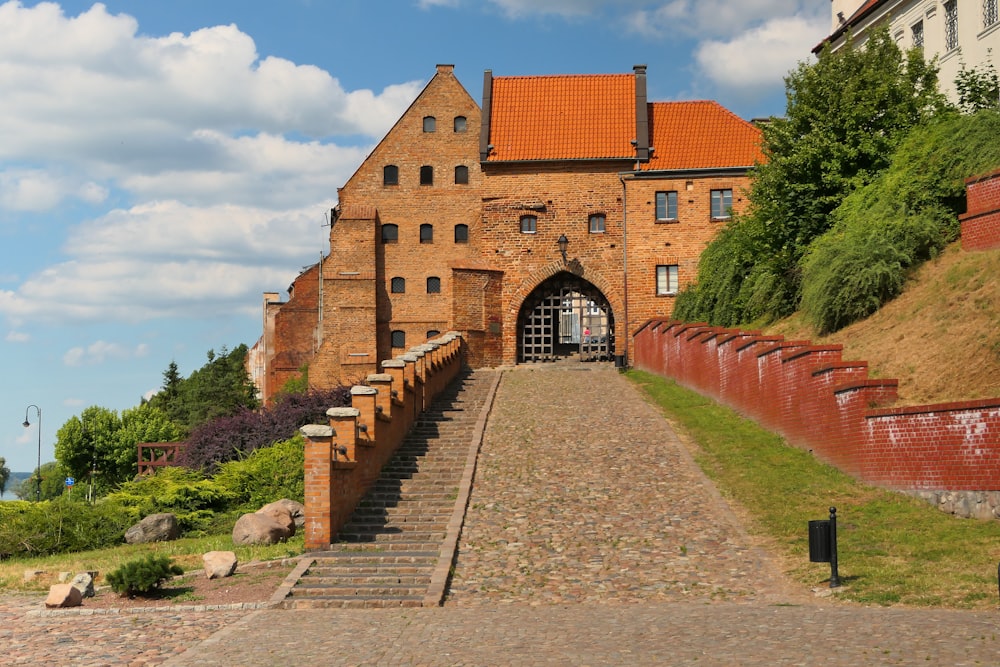 a brick building with a stone walkway leading to it