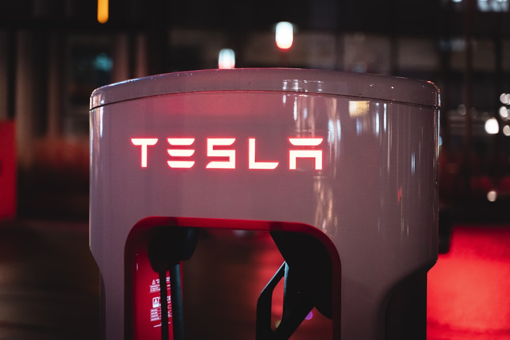 a red tesla logo on a white machine