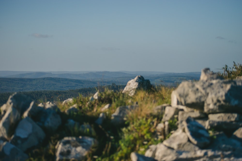 a rocky outcropping with a view of mountains in the distance